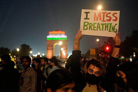 A person holds a sign during a protest against what they called the government's lack of action to combat air pollution in New Delhi, India, Nov. 9, 2025.