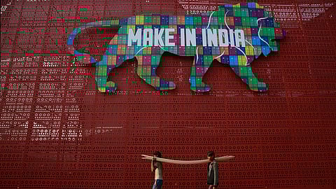 Laborers carry narrow planks of wood to be used for building a pavilion for the Make in India summit in Mumbai, India, Feb. 9, 2016.