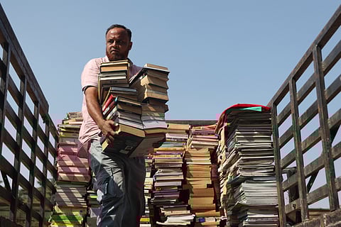 A book stall vendor unloads book bundles from a truck at NTR stadium in Hyderabad ahead of the 38th Hyderabad Book Fair that is to be held from December 19th to 29th.