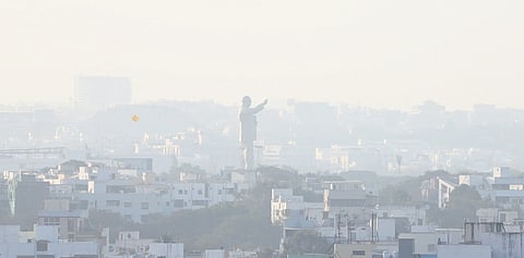 The Dr BR Ambedkar statue stands above a dense layer of smog covering residential buildings on Friday amid worsening air quality in Hyderabad.