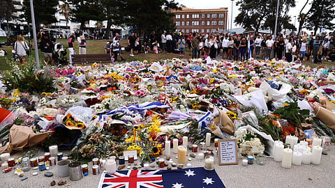 Mourners gather around floral tributes at Bondi Pavilion to honor the victims of the Bondi Beach shooting in Sydney on December 16, 2025.