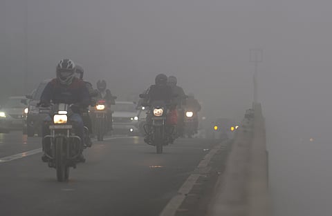 Vehicles ply on a road amid dense fog on a winter morning, in New Delhi, Friday, Dec. 19, 2025.