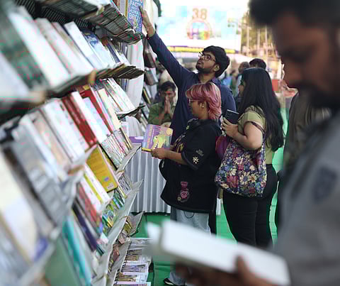 Visitors browse through stacks of books at a stall during the Hyderabad Book Fair at NTR Grounds in Hyderabad on Friday.
