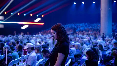 An attendee prays during Turning Point USA's AmericaFest 2025, Thursday, Dec. 18, 2025, in Phoenix.