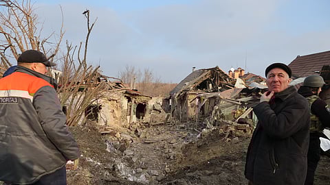 Local residents look at a residential house destroyed after a Russian attack on Zaporizhzhia, Ukraine, Friday, Dec. 19, 2025.