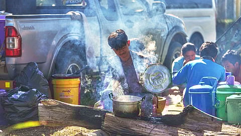 A Thai resident from fighting between Thailand and Cambodia along the border cooks at an evacuation center in Surin province, Thailand, Tuesday, Dec. 16, 2025.