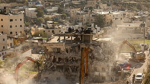 Excavators demolish a building constructed without a permit in the Wadi Qaddum area near the Silwan neighbourhood of east Jerusalem on December 22, 2025.