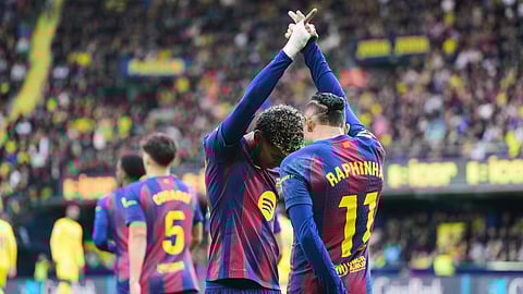 Barcelona's Raphinha (R), celebrates with his teammate Barcelona's Lamine Yamal after scoring the opening goal from a penalty kick during the Spanish La Liga soccer match between Villarreal and Barcelona on Dec. 21, 2025.