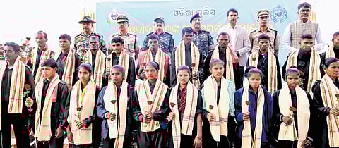 Maoist cadres pose with DGP YB Khurania and senior police officials after their surrender at Malkangiri on Tuesday.