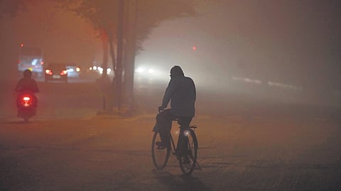 A commuter with his face covered on a foggy winter morning in New Delhi on Tuesday.