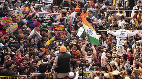 Vishwa Hindu Parishad (VHP) and Bajrang Dal members wave the national flag during a protest outside the Bangladesh High Commission over attacks on Hindus in the neighbouring country, in New Delhi, Tuesday, Dec. 23, 2025