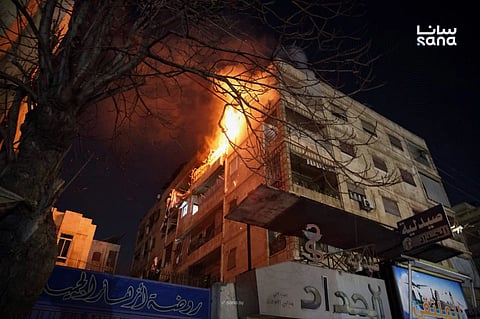 This photo released by the official Syrian news agency SANA, shows flames rising from a building after clashes broke out between security forces and Kurdish fighters in neighbourhoods of the northern Syrian city of Aleppo, Syria, Monday, Dec 22, 2025.