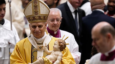 Pope Leo XIV holds the statue of Baby Jesus during the Christmas Eve Mass in St. Peter's Basilica at The Vatican, Wednesday, Dec. 24, 2025.