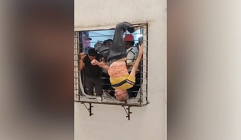 Nitinbhai Adia being rescued by fire brigade personnel after falling from a high-rise building.