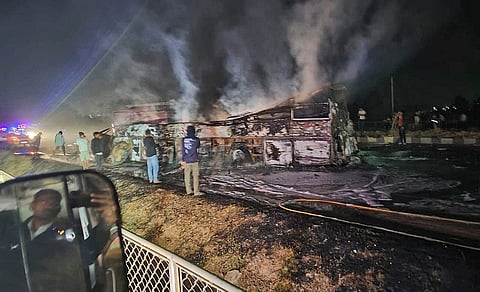 Fire personnel douse the flames after a truck and bus caught fire following a collision on NH-48 in Chitradurga district in the early hours of Thursday