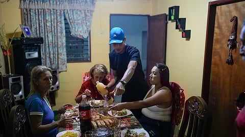 Mariela Gómez, right, and her partner Abraham Castro, a Venezuelan migrant couple, sit for Christmas dinner at Castro's parents' home in Maracay, Venezuela, early Thursday, Dec. 25, 2025.