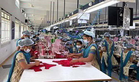 Workers engaged in production at a private knitwear manufacturing company in Tiruppur.