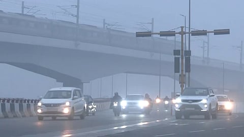 Vehicles commute through the Barapullah flyover area covered with smog amid worsening air quality in Delhi.
