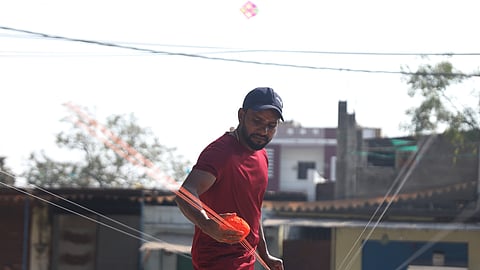 A man applies manja to a kite string, a traditional yet dangerous practice ahead of the Sankranti at Mangalhat in Hyderabad.