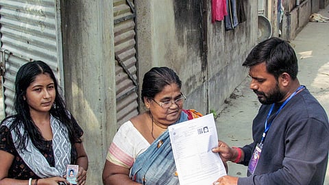 An official distributes an SIR form in the Karimpur assembly constituency, in Nadia, West Bengal.
