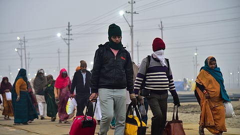 People arrive to perform rituals at the Sangam during a cold and foggy winter morning, in Prayagraj, Saturday, Dec. 27, 2025.
