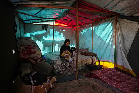 Shaimaa Wadi, 25, sits with her 1-year-old daughter Tala, inside their tent in a makeshift camp for displaced Palestinians in Deir al-Balah, central Gaza Strip, Saturday, Dec. 27, 2025.