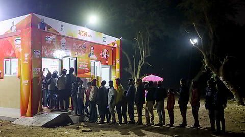 People line up outside an Atal Canteen to avail subsidised meals under the government-run food scheme in New Delhi, Friday, Dec. 26, 2025.