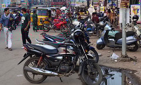 Vehicles parked in the road affecting traffic movement in Madurai roads.