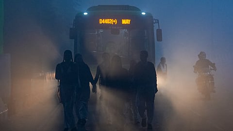 Students walk along a road on their way to school amid dense fog on a winter morning, in New Delhi, Monday, Dec. 29, 2025.