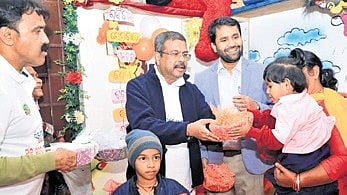 Union Minister Pradhan distributing fruits at an aganwadi centre.