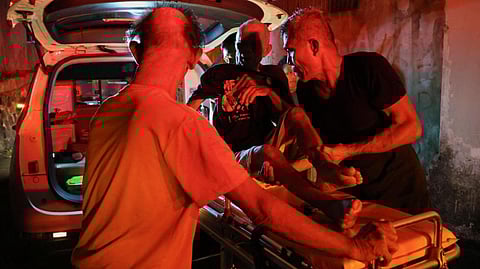 Local people rescue an elderly man during a fire at Werdha Damai retirement home in Manado, North Sulawesi Province, Indonesia, December 28, 2025.