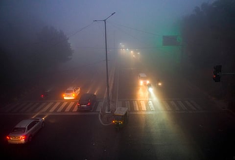Vehicles ply a road amid dense fog on a cold winter morning, in New Delhi, Wednesday, Dec. 31, 2025.