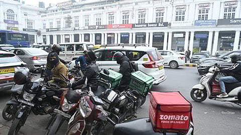 Gig and platform workers prepare to deliver orders at a market area in New Delhi on Wednesday.