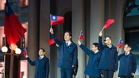 Taiwanese President Lai Ching-te, center, is accompanied by his Vice President Bi-Khim Hsiao, second right, and officials wave national flags as they attend a New Year flag raising ceremony at the Presidential Office, in Taipei, Taiwan, Thursday, Jan. 1, 2026.