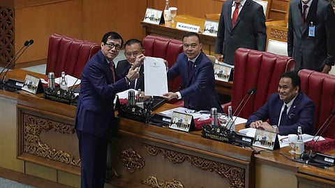 Indonesian Law and Human Rights Minister Yasonna Laoly, left, poses for the media with Deputy House Speaker Sufmi Dasco Ahmad, center, during a session ratifying the country's new criminal code at the parliament building in Jakarta, Indonesia, Tuesday, Dec. 6, 2022.