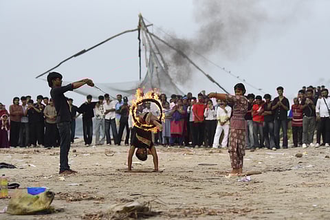 Anand jumps through a ring of fire held by his son Arun and daughter Archana