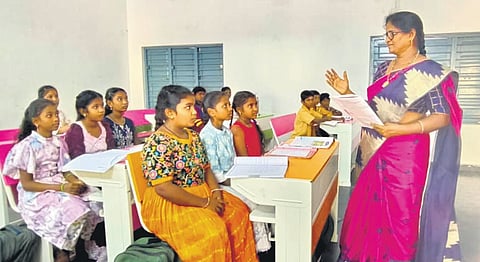 Government teacher Sarada teaches students in school.