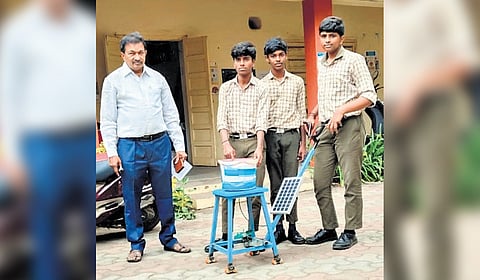 Students and HM shows "Easy Broadcast Spreader" Machine.