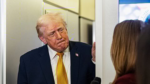 US President Donald Trump speaks with reporters while in flight on Air Force One, Sunday, Jan. 4, 2026, as he returns to Joint Base Andrews, Md.