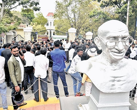 People gather outside the old court premises following a hoax bomb email, in Mysuru on Tuesday.
