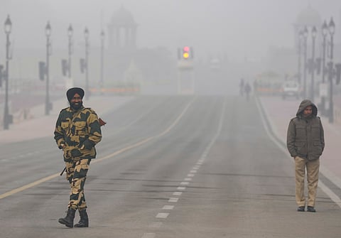 Security personnel keep vigil on a foggy winter morning, in New Delhi, Tuesday, Jan. 6, 2026.