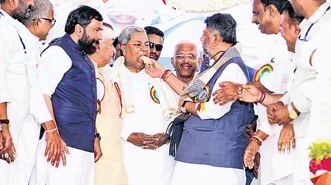 Chief Minister Siddaramaiah being offered cake by Deputy Chief Minister DK Shivakumar during the inauguration and foundation stone laying ceremony of various development initiatives, in Haveri on Wednesday