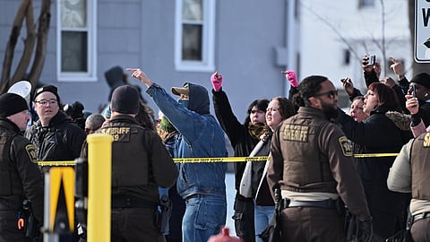People protest as law enforcement officers attend to the scene of the shooting involving federal law enforcement agents, Wednesday, Jan. 7, 2026, in Minneapolis.