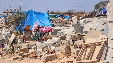 A man breaks stones to prepare a makeshift home amidst the ble caused by the eviction drive at Kogilu, Bengaluru.