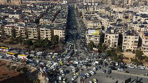 An aerial view shows Syrian residents in vehicles, queueing to flee from Sheikh Maqsoud and Achrafieh neighborhoods after clashes broke out on Tuesday between Syrian government forces and Kurdish fighters in a contested area of the northern city of Aleppo, Syria, Wednesday, Jan. 7, 2026