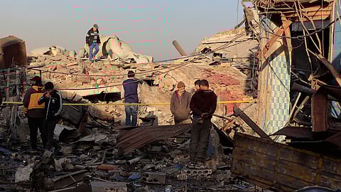 People check the site where an Israeli strike destroyed a building at a commercial district in the southern port city of Sidon, Lebanon, Tuesday, Jan. 6, 2026.