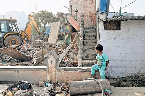 A child watches as a BDA bulldozer demolishes his house in Thanisandra on Thursday