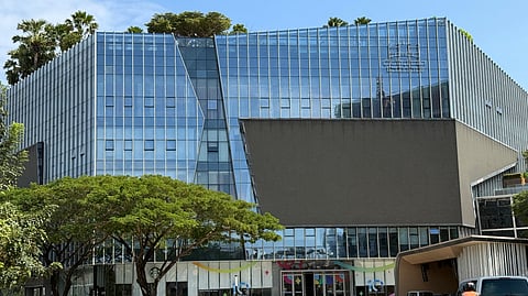 Motorists ride past the Prince Group Headquarters in Phnom Penh on January 8, 2026. A Cambodian bank founded by accused scam boss Chen Zhi, who has been indicted by the US and extradited to China.