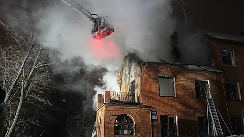 Rescue workers put out a fire at a residential building damaged by a Russian strike in Kyiv, Ukraine, Friday, Jan. 9, 2026.