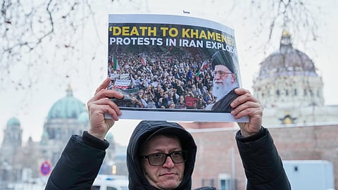 Protesters show signs against Iran leader Ali Khamenei during a demonstration in Berlin, Germany, in support of the nationwide mass protests in Iran against the government, Friday, Jan. 9, 2026.